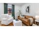 Bright living room featuring a brown leather sofa, white arm chair, and white ottoman at 5351 Carson St, St Cloud, FL 34771