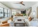 Bright living room with staircase view, large windows offering natural light, and open concept to kitchen area at 5351 Carson St, St Cloud, FL 34771