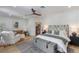Spacious main bedroom with a seating area, decorative ceiling fan, and a door leading to the bathroom at 5351 Carson St, St Cloud, FL 34771