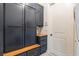 Mudroom featuring custom navy blue storage cabinets, a seating bench, and a neutral color scheme at 5351 Carson St, St Cloud, FL 34771