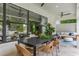 Covered outdoor patio featuring a dining table and an adjacent lounge area with views of the lush backyard at 5351 Carson St, St Cloud, FL 34771