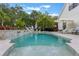 A luxurious backyard pool with a beautiful waterfall feature is surrounded by lush landscaping and lounge chairs at 5351 Carson St, St Cloud, FL 34771
