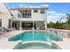 This backyard boasts a sparkling pool, covered patio with dining, and a lounging area ideal for entertaining guests at 5351 Carson St, St Cloud, FL 34771