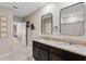Bathroom with dual sink vanity featuring granite counters, framed mirrors, and neutral paint at 5515 Palomino Pl, Apopka, FL 32712