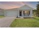 Charming single-Gathering home featuring a well-manicured lawn, two-car garage, and cozy front porch sitting area at 5515 Palomino Pl, Apopka, FL 32712