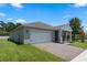 Well-maintained home showcasing a paved driveway, two-car garage, and lush green lawn at 5515 Palomino Pl, Apopka, FL 32712
