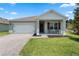 Charming single-story home featuring a two-car garage, manicured lawn and a cozy front porch at 5515 Palomino Pl, Apopka, FL 32712