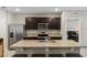 Modern kitchen with dark wood cabinets, stainless steel appliances, and granite countertops at 5515 Palomino Pl, Apopka, FL 32712