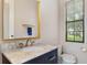Stylish bathroom featuring marble vanity with gold accents and a large window offering natural light at 6149 Blakeford Dr, Windermere, FL 34786