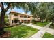 Charming two-story home featuring a tile roof, balcony, with mature trees and a manicured lawn at 6149 Blakeford Dr, Windermere, FL 34786