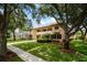 Elegant two-story home with a tile roof, balcony, manicured lawn, and mature trees at 6149 Blakeford Dr, Windermere, FL 34786