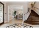 Inviting foyer featuring dark-stained hardwood stairs and a view into the dining room with natural light at 6149 Blakeford Dr, Windermere, FL 34786