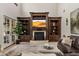Cozy living room featuring custom built-in shelving, fireplace, and a large television for entertainment at 6149 Blakeford Dr, Windermere, FL 34786