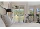 A sunlit main bedroom featuring access to a private balcony with views of the backyard and a home gym at 6149 Blakeford Dr, Windermere, FL 34786