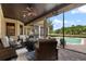 Covered outdoor patio features seating, ceiling fan and pool with views of the golf course at 6149 Blakeford Dr, Windermere, FL 34786