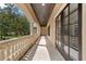 Long, covered porch featuring white columns, stone railing, brick flooring, and natural lighting at 6149 Blakeford Dr, Windermere, FL 34786