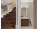 Wooden staircase with decorative metal railing next to a half bathroom featuring a modern vanity at 6149 Blakeford Dr, Windermere, FL 34786