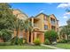 Attractive condo building showcasing well-maintained landscaping and classic architectural details under a blue sky at 6335 Contessa Dr # 208, Orlando, FL 32829