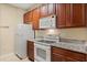 Kitchen featuring granite countertops, white appliances, and ample cabinet space for a practical cooking area at 6335 Contessa Dr # 208, Orlando, FL 32829