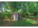 Backyard featuring a storage shed with open doors surrounded by trees at 817 Big Buck Cir, Winter Springs, FL 32708