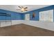 A blue bedroom features a ceiling fan, carpeted floors, and two windows at 817 Big Buck Cir, Winter Springs, FL 32708