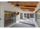 Enclosed patio with wood plank ceiling, ceiling fan, TV, and sliding glass doors at 817 Big Buck Cir, Winter Springs, FL 32708