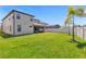Large backyard with lush green grass, white fence, and mature palm trees at 8348 Vivaro Isle Way, Windermere, FL 34786