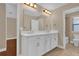 Bathroom features double sinks with vanity and a large mirror with lighting, adding elegance at 8348 Vivaro Isle Way, Windermere, FL 34786