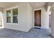 Inviting entryway with a brown front door, brick floor, window, and neutral-toned wall at 8348 Vivaro Isle Way, Windermere, FL 34786