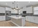 Bright kitchen features white cabinets, stainless steel appliances, blue backsplash, and a center island with a quartz countertop at 8348 Vivaro Isle Way, Windermere, FL 34786