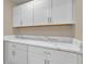 Bright laundry cabinets with quartz countertops offer ample storage and a clean, modern look at 8348 Vivaro Isle Way, Windermere, FL 34786
