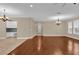 Spacious living room with hardwood floors, chandeliers, and many windows at 8348 Vivaro Isle Way, Windermere, FL 34786