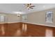 Living room showcasing wood flooring, recessed lighting, large windows, and an open entryway to the kitchen at 8348 Vivaro Isle Way, Windermere, FL 34786