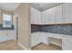 Cozy office space featuring built-in white cabinets and granite countertops with a mosaic backsplash at 8348 Vivaro Isle Way, Windermere, FL 34786