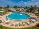 Aerial view of a relaxing community pool, featuring ample lounge seating and shaded tables to enjoy the sunny outdoors at 9000 Us Highway 192 # 115, Clermont, FL 34714