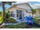 Quaint single-story home with a sunroom, a blue chair, potted plants, and a well-kept garden, radiating curb appeal at 9000 Us Highway 192 # 115, Clermont, FL 34714