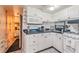 Bright kitchen featuring white cabinetry, black marble countertops, and modern appliances at 9000 Us Highway 192 # 115, Clermont, FL 34714