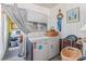 Functional laundry area features a washer, dryer, and a beach-themed artwork, blending practicality and style at 9000 Us Highway 192 # 115, Clermont, FL 34714