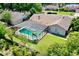 An aerial view showcasing the home's screened pool, lush backyard, and neighborhood setting at 957 Yellow Rose Dr, Orlando, FL 32818