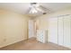 Well-lit bedroom with plush carpeting, ceiling fan, and white closet and dresser at 957 Yellow Rose Dr, Orlando, FL 32818