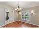 Dining room with hardwood floors, a chandelier, sconces, and a window with custom plantation shutters at 957 Yellow Rose Dr, Orlando, FL 32818
