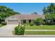 Charming single-story home with well-manicured landscaping, inviting curb appeal, and attached two-car garage at 957 Yellow Rose Dr, Orlando, FL 32818