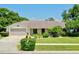 Charming single-story home with a well-manicured lawn, mature landscaping, and attached garage at 957 Yellow Rose Dr, Orlando, FL 32818