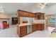 Open kitchen features wooden cabinets, stainless appliances, and a view into the living room and dining area at 957 Yellow Rose Dr, Orlando, FL 32818