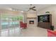 Cozy living area featuring a brick fireplace, tile floors, and sliding doors to the screened-in pool area at 957 Yellow Rose Dr, Orlando, FL 32818