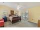 Serene main bedroom with vaulted ceiling, ensuite bathroom, and slider access to the screened in pool at 957 Yellow Rose Dr, Orlando, FL 32818