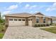 Beautiful home exterior with a three-car garage, stone accents, and well-maintained landscaping at 9846 Sw 106Th Ct Ocala, F, Ocala, FL 34481