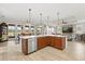 Modern kitchen island with wood cabinets and stainless steel appliances overlooking the living area at 9846 Sw 106Th Ct Ocala, F, Ocala, FL 34481
