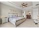 Comfortable bedroom with tray ceilings, a ceiling fan, an en suite bathroom, and a king-size bed at 9846 Sw 106Th Ct Ocala, F, Ocala, FL 34481