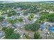 Elevated aerial view of a home featuring a garden, pool, and flourishing trees in a peaceful neighborhood setting at 10739 Lake Ralph Dr, Clermont, FL 34711